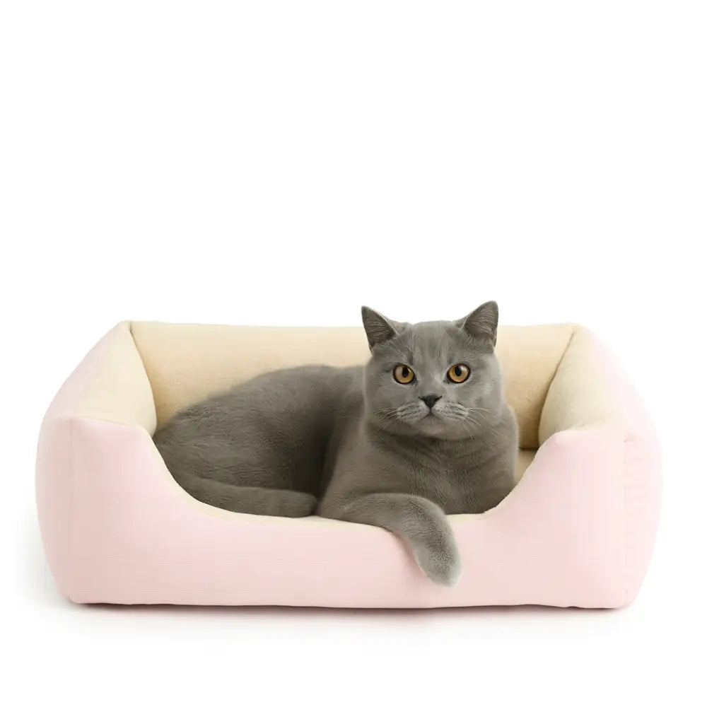 Panier pour chat confortable de couleur rose et beige avec coussin doux, parfait pour offrir un espace de repos chaleureux à ton chat.