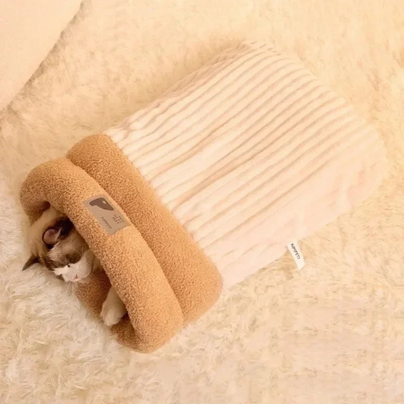 Chat installé dans un sac de couchage beige et blanc pour chat, col en peluche douce