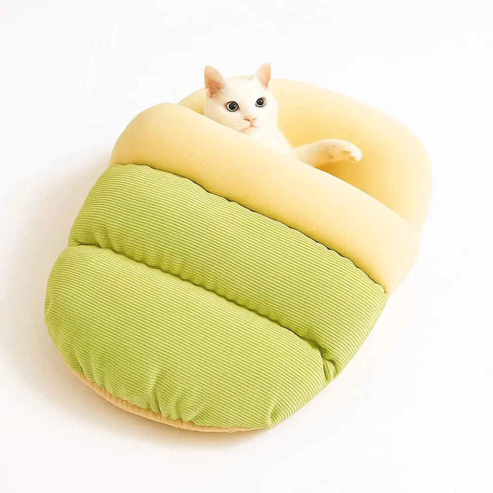 Chat installé dans un sac de couchage pour chat en coton vert et beige, lit douillet et respirant.